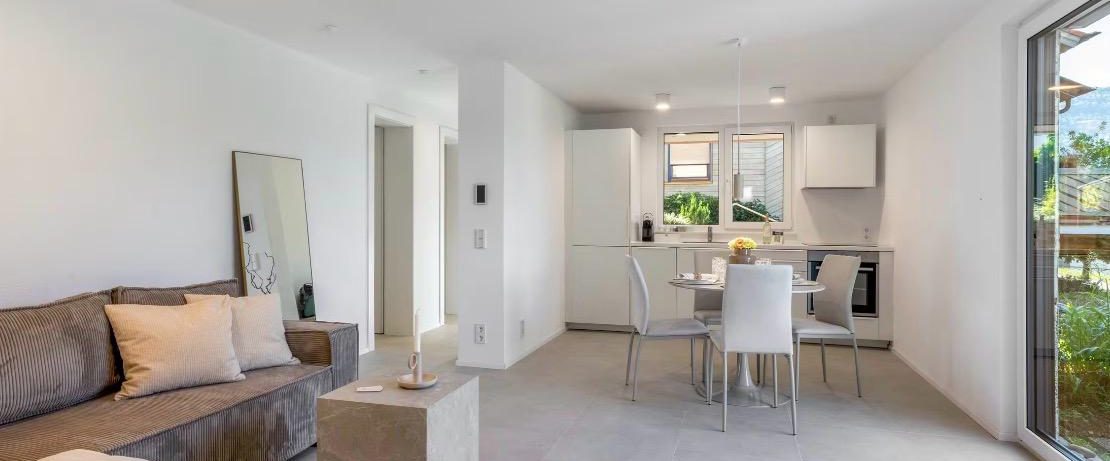 Wohnzimmer mit Sofa, Essplatz und Küche in der Ferienwohnung Casa Panorama